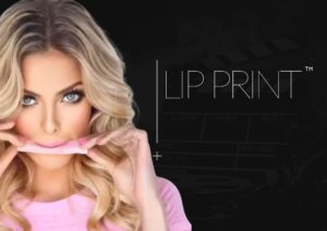 Kobieta o długich blond włosach nakłada arkusz Lip Print™ na usta, z tłem w postaci klapera i wyraźnym oznaczeniem nazwy produktu.