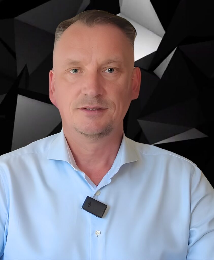 Mężczyzna w jasnej koszuli na tle geometrycznego, czarno-białego wzoru