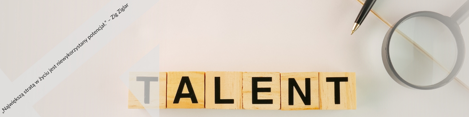Zdjęcie przedstawia drewniane klocki ułożone w słowo "TALENT" na jasnym tle. Obok znajdują się lupę i pióro, symbolizujące analizę i kreatywność. W tle widoczny jest fragment papieru z cytatem Ziga Ziglara: "Największa strata w życiu to niewykorzystany potencjał".